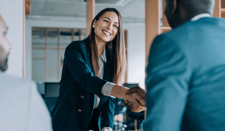 Two people shaking hands over a business deal